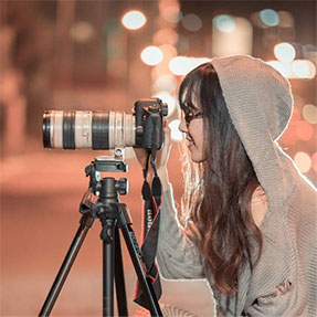 jeune femme en train de prendre une photo avec téléobjectif